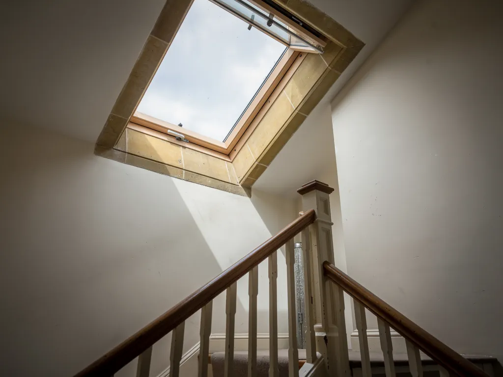 An electric rooflight open over a top-floor landing