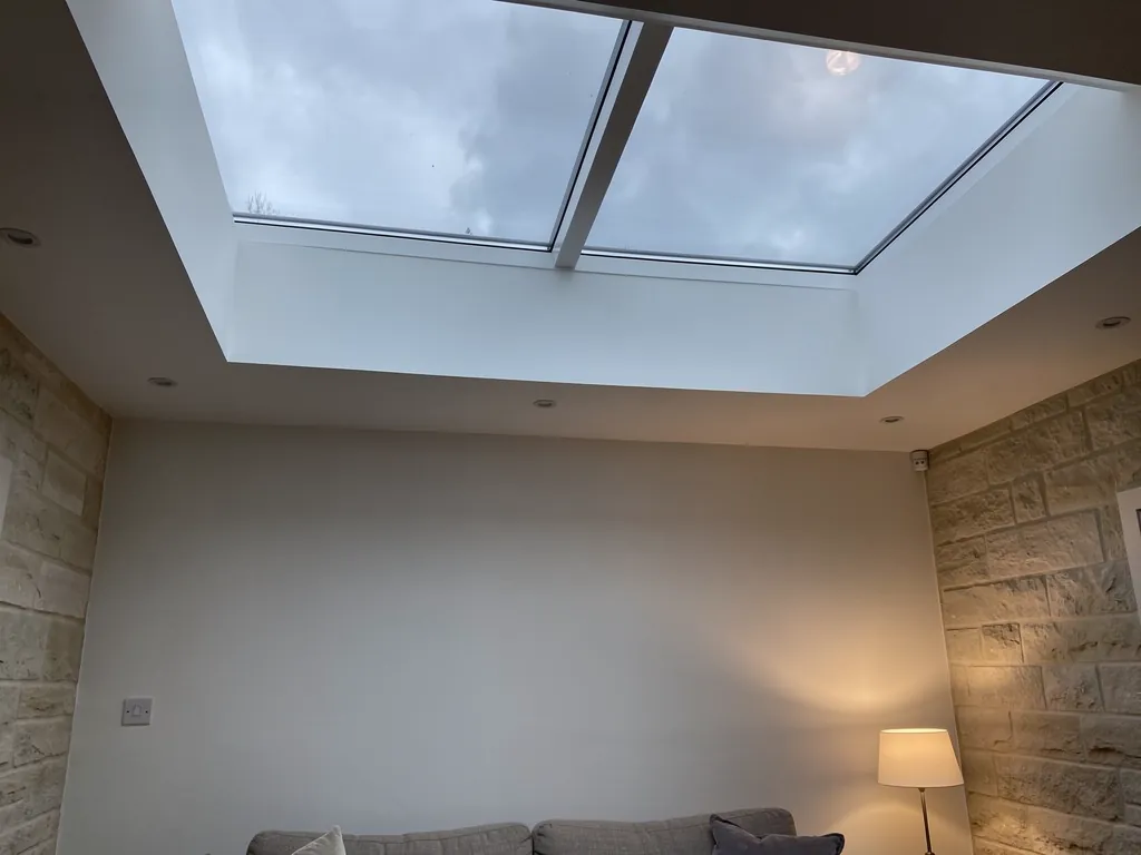A triple-glazed flat rooflight over a warm living room