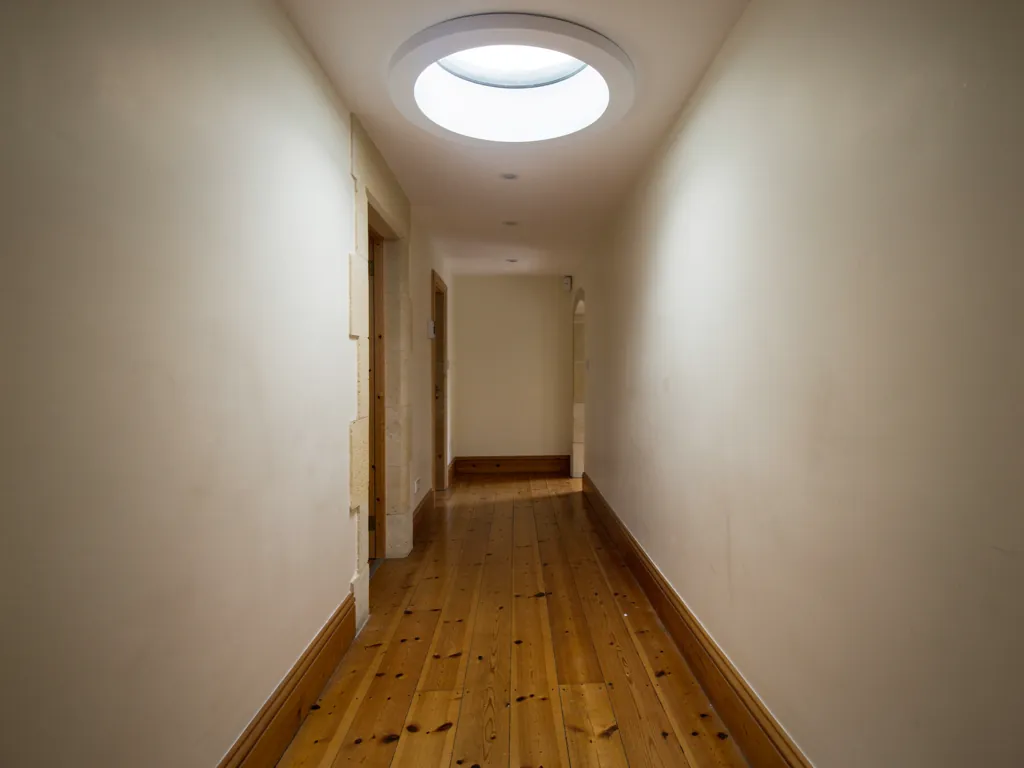 A sun tunnel lighting a dark hallway