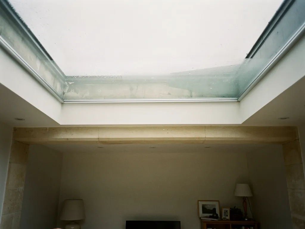 Daylight falling through a walk-on glass rooflight into a room below